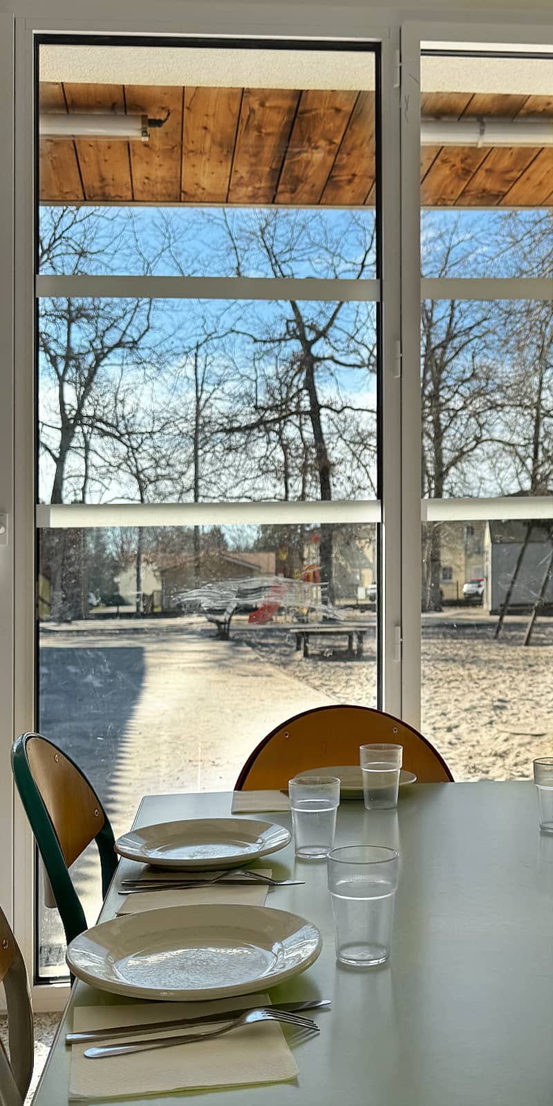 vue d'ensemble de la cantine, avec les tables dressées, prêtes à accueillir les enfants