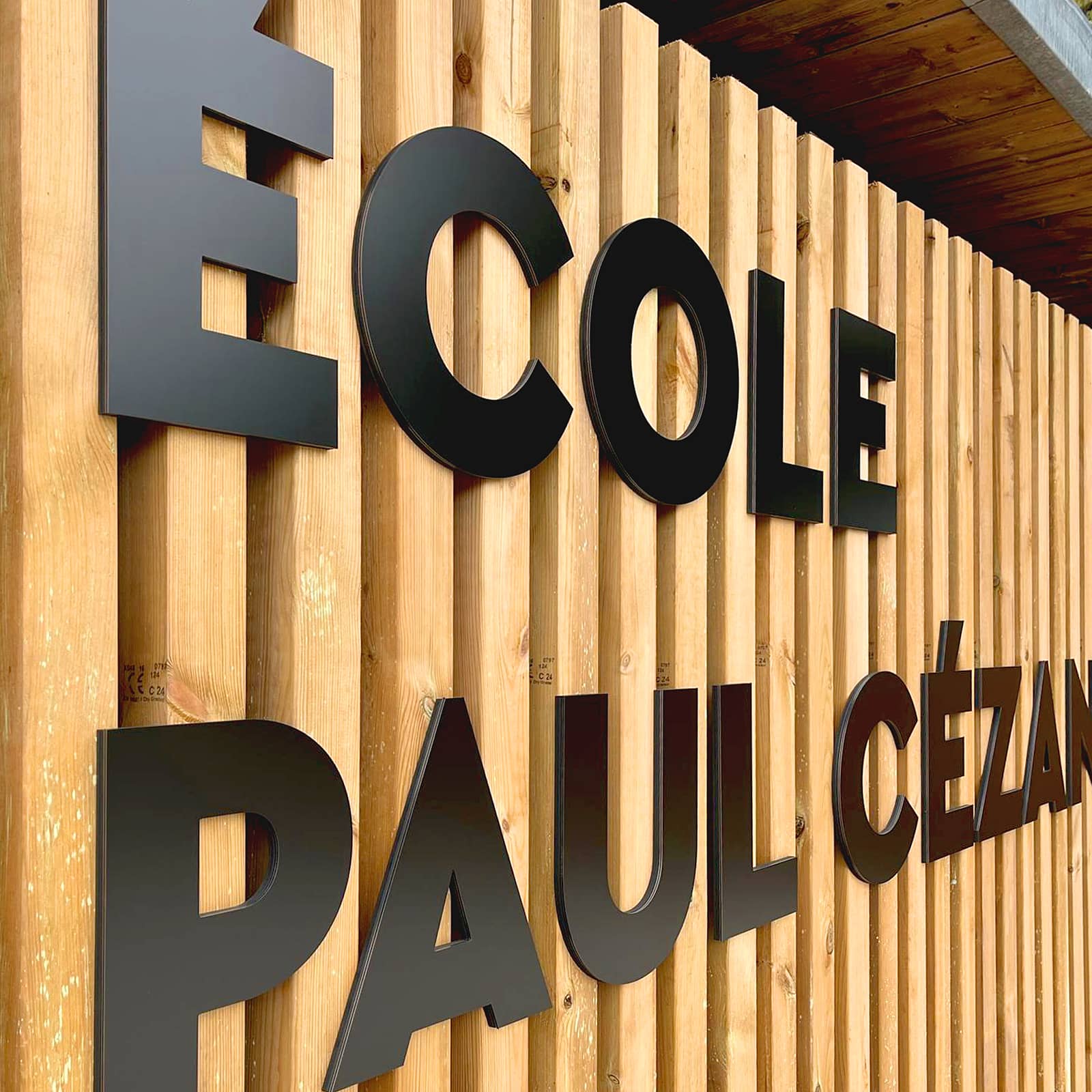 détail sur le bardage bois et le nom de l'école
