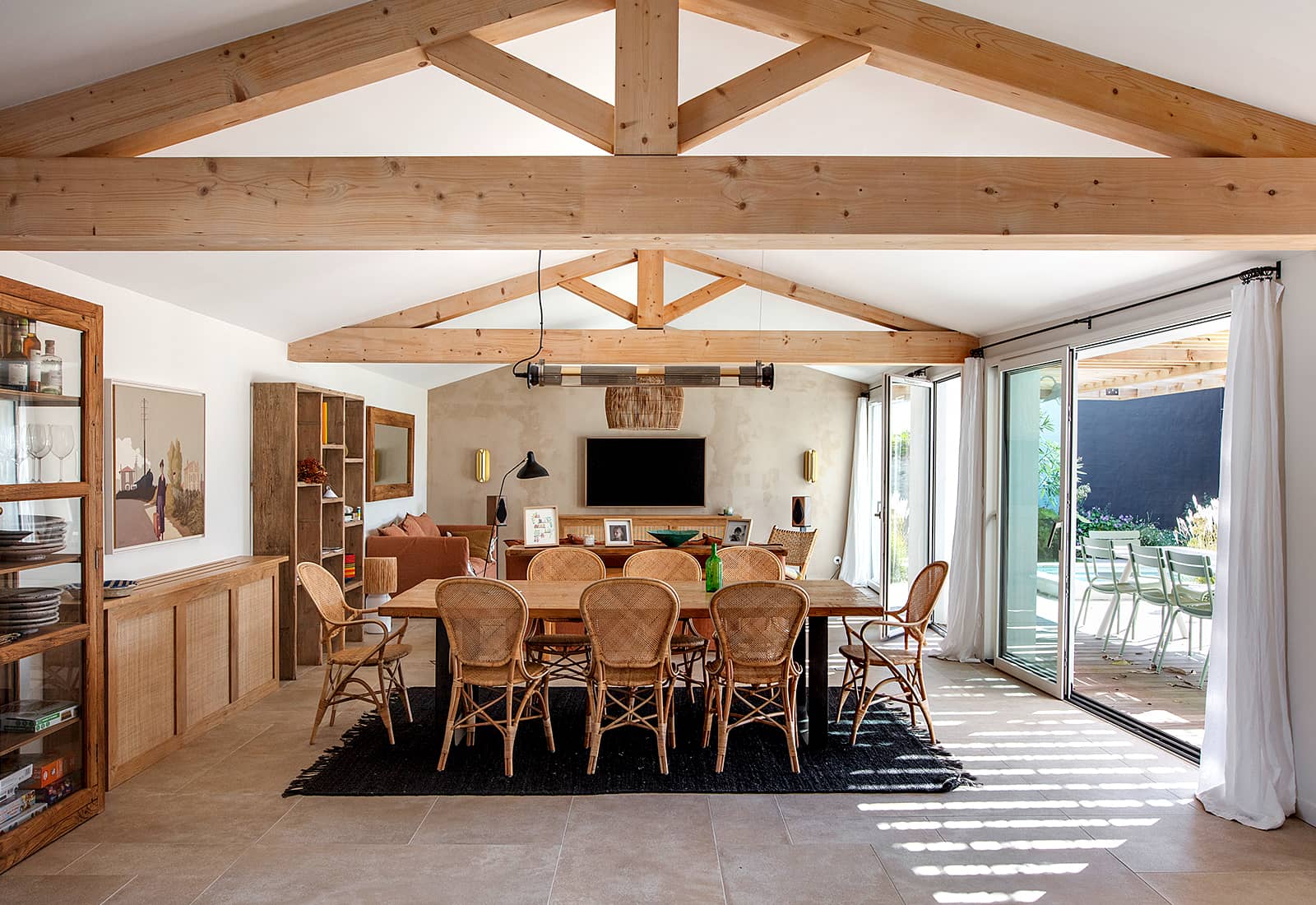 vue de l'aménagement intérieur avec ses poutres en bois et ses baies vitrées ouvrant sur la terrasse