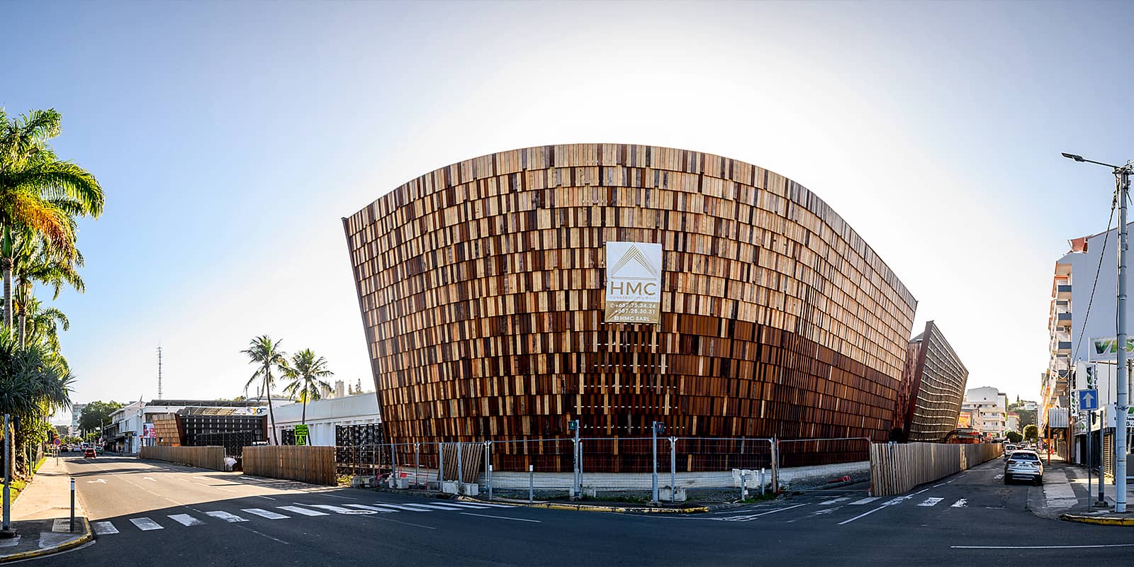 photo de chantier montrant des artisans dans une nacelle, œuvrant à l'installation du lattis bois