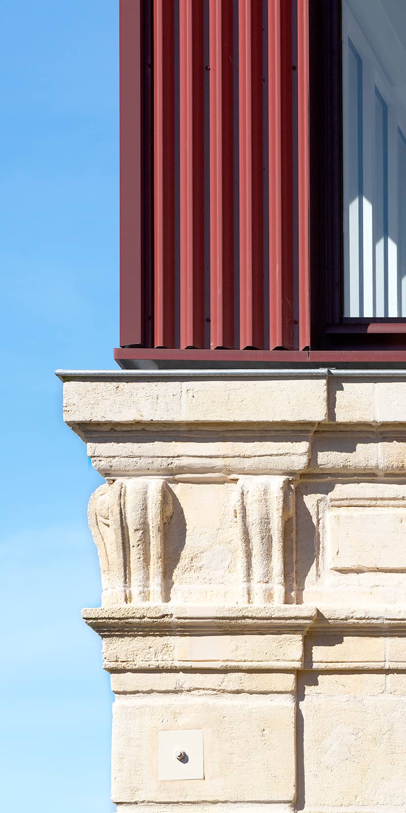Détail de la juxtaposition de l'ancien en pierre et de l'extension en métal