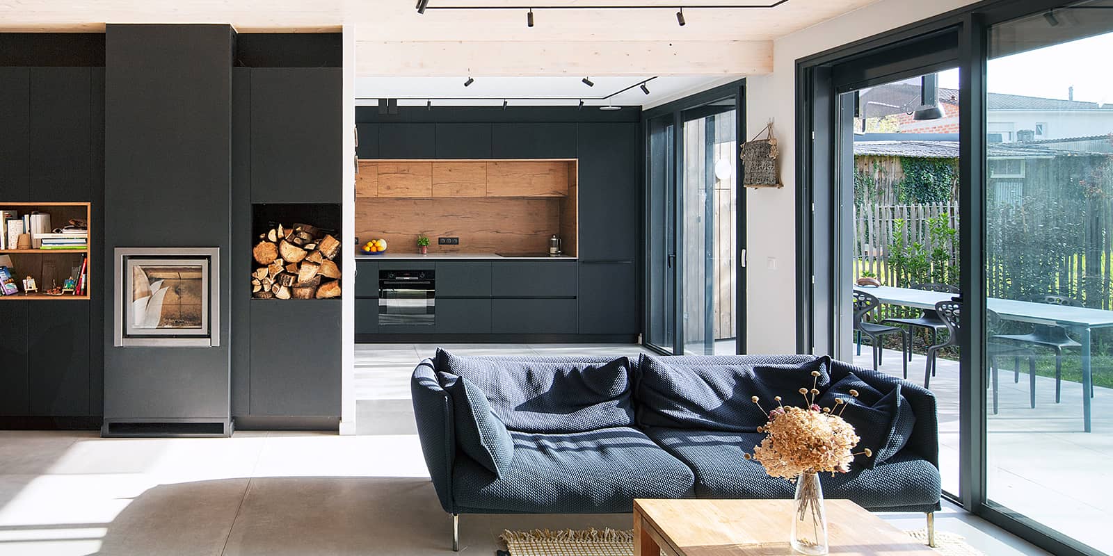 aménagement intérieur avec poele au bois et baie vitrée sur la terrasse